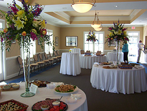 large decorated room with tables full of food and tall floral centerpieces